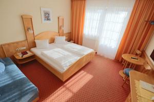 Habitación de hotel con cama grande y ventana en Panoramahof Ziegler, en Bad Waltersdorf