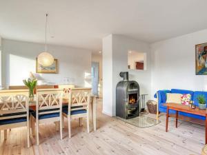 a kitchen and living room with a table and a fireplace at Holiday home Strandby XII in Strandby