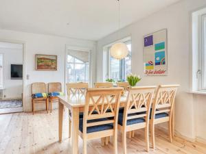 a dining room with a wooden table and chairs at Holiday home Strandby XII in Strandby