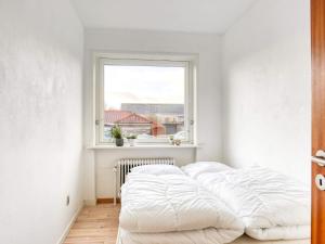 a bed in a room with a window at Holiday home Strandby XII in Strandby