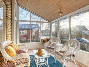 un porche cubierto con sillas de mimbre y un sofá en Holiday home Strandby XII en Strandby