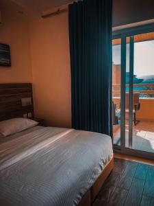 Schlafzimmer mit einem Bett und Blick auf einen Balkon in der Unterkunft La Riva Hotel in Aqaba