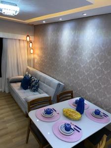 Belo apartamento Ondina Apart في سلفادور: غرفة معيشة مع طاولتين وأريكة