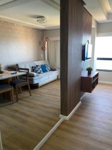 uma sala de estar com um sofá e uma mesa em Belo apartamento Ondina Apart em Salvador