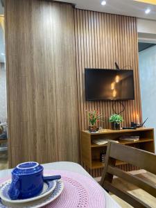 a room with a table and a television on a wall at Belo apartamento Ondina Apart in Salvador