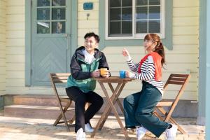 mężczyzna i kobieta siedzący przy stole w obiekcie Cottage Morinokokage w mieście Yakushima