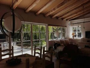 a living room with large windows and a couch at Casa Ramal in Ciudad Lujan de Cuyo