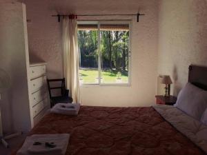 Un dormitorio con una cama grande y una ventana en Casa Ramal en Luján de Cuyo