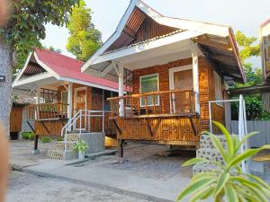 a wooden house with a porch and a balcony at BFF Backpacker's Inn in San Vicente