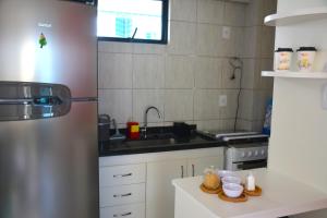 una cocina con fregadero y refrigerador en Apto1003 - Conde da Praia - Vista Mar, en Natal