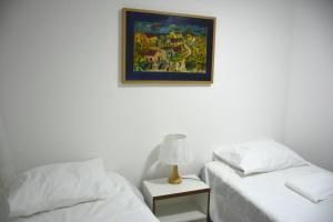 Un dormitorio con dos camas y un cuadro en la pared. en Apto1003 - Conde da Praia - Vista Mar, en Natal