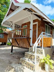 une terrasse couverte d'une maison avec un auvent blanc dans l'établissement BFF Backpacker's Inn, à San Vicente