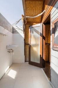 un baño vacío con puerta y lavabo en Deep House Bungalows en Gili Trawangan