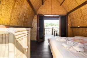 a room with two beds in a room with a doorway at Deep House Bungalows in Gili Trawangan