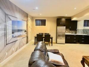 a living room with a leather couch and a kitchen at Luxury 3700 sq/ 5 bedroom/ jettedtub/ 4 fireplaces in Edmonton