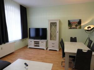 ein Wohnzimmer mit einem Flachbild-TV und einem Tisch in der Unterkunft Apartment in the center of Ballenstedt in Ballenstedt