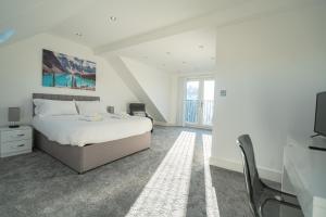 Newly Refurbished Modern 4 Bed Detached House ! في أوكسفورد: غرفة نوم بيضاء مع سرير وتلفزيون
