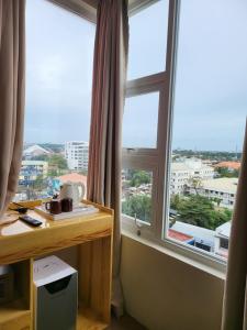 um quarto com 2 janelas grandes e uma secretária com uma secretária. em Sempre Premier Inn - MACTAN AIRPORT HOTEL em Mactan