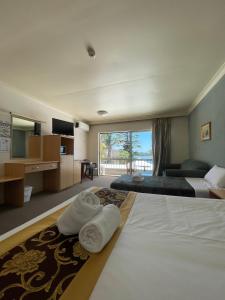 Habitación de hotel con 2 camas y ventana grande. en El Lago Waters Resort, en The Entrance