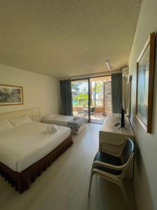 ザ・エントランスにあるEl Lago Waters Resortのベッドルーム1室(ベッド1台、デスク、コンピュータ付)