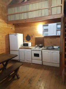 a kitchen with white appliances and a wooden wall at Albaricoque in Tigre