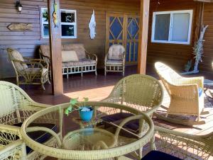 Sandy BayにあるReef Beach House - 2 Bedrooms and studioのパティオ(籐の椅子、ポーチテーブル付)