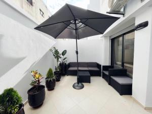a patio with an umbrella and chairs and potted plants at High Standing & cozy apartment in central Casablanca in Casablanca