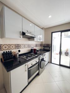 a kitchen with white cabinets and a stove top oven at High Standing & cozy apartment in central Casablanca in Casablanca