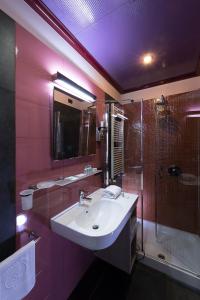 y baño de color rosa con lavabo y ducha. en Hotel La Pioppa en Bolonia