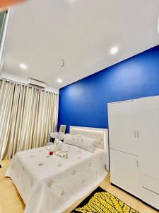 una camera con un letto bianco e una parete blu di The Palace Guest House, Seri Gading Batu Pahat a Batu Pahat