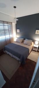 ein Schlafzimmer mit einem großen Bett mit einer blauen Decke in der Unterkunft Dpto panorámico chic microcentro in Mendoza