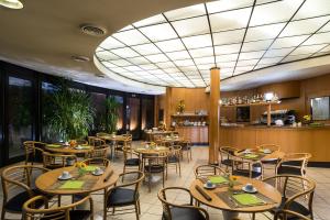 a restaurant with tables and chairs and a bar at Hotel La Pioppa in Bologna