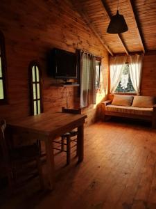 una sala de estar con una mesa y un sofá en una cabaña en Albaricoque en Tigre