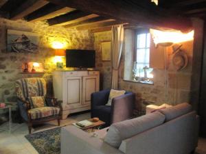 sala de estar con sofá, sillas y TV en Gîte Bourbon-l'Archambault, 3 pièces, 4 personnes - FR-1-489-293, en Bourbon-l'Archambault