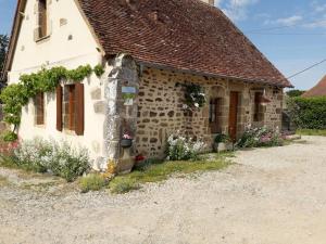 una casa de piedra con flores delante en Gîte Bourbon-l'Archambault, 3 pièces, 4 personnes - FR-1-489-293, en Bourbon-l'Archambault