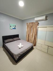 a bedroom with a bed and a air conditioner at Le'Coco Homestay Tiara Desaru Pool View in Desaru +52 photos