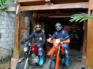 two people on motorcycles parked in a garage at Linh Homestay and motorbikes rent in Ha Giang