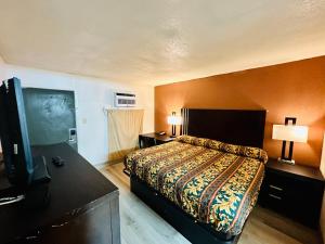 1 dormitorio con 1 cama y TV de pantalla plana en Economy Inn, en Houma