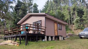 a house with a deck and a car parked in front of it at Cabañas Isla Del rey in Valdivia +26 photos