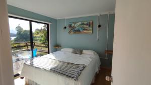 a bedroom with a bed and a large window at Cabañas Isla Del rey in Valdivia