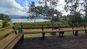 a wooden bench on a deck with a view of a lake at Cabañas Isla Del rey in Valdivia