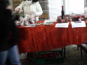 una mujer de pie detrás de una mesa roja con comida en The Italian countryside - Agriturismo Collina Delle Streghe, 