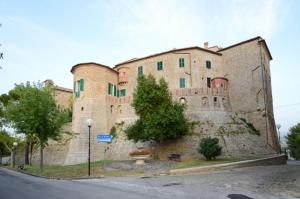 un grande edificio in pietra sul lato di una strada di The Italian countryside - Agriturismo Collina Delle Streghe 