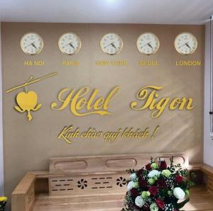 a wall with clocks on a wall with a nel sign at TiGon Hotel in Ha Long