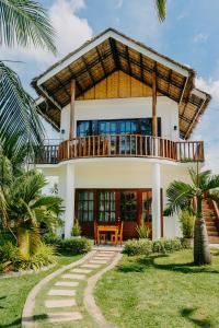 a house with a balcony on top of it at Palmera Palma Garden Level in Moalboal