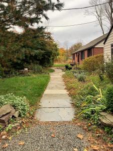 a sidewalk in a yard next to a house at Cozy Ranch by the Trail & Sleeping Giant in Hamden