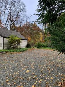 a driveway in front of a house with leaves on the ground at Cozy Ranch by the Trail & Sleeping Giant in Hamden