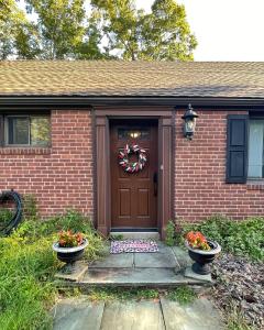 a house with a door with a wreath on it at Cozy Ranch by the Trail & Sleeping Giant in Hamden