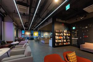 eine Bibliothek mit Sofas, Tischen und Büchern in der Unterkunft Aiden by Best Western Cheongdam in Seoul