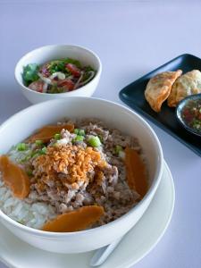 a bowl of rice and vegetables and a plate of food at tt Residence in Chachoengsao
